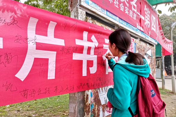 24a09e2946554c9b8562045897a390ac.jpg 参与活动的同学在横幅上签名.jpg
